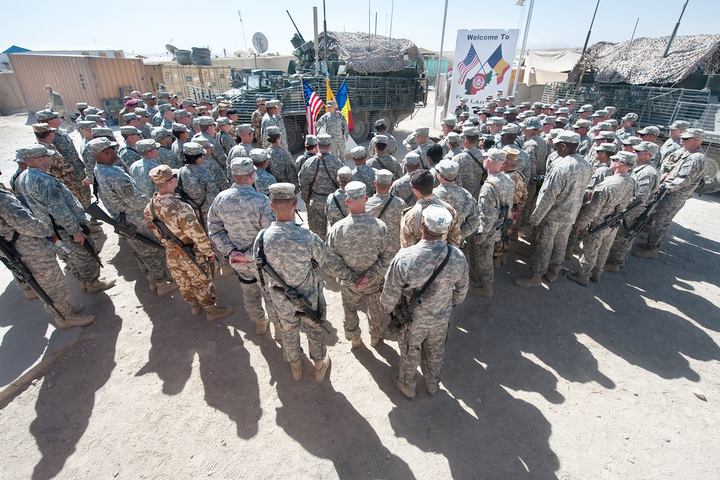 US and Romanian Soldiers huddle to listen to an address from the Chief of Staff of the US Army, Gen. George W. Casey Jr., at Camp Laughman, Afghanistan, Oct. 11, 2010.