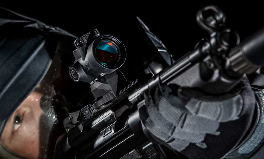 3 Best Budget AR-15 Red Dot Sights Man looking through the Trijicon MRO red dot sight