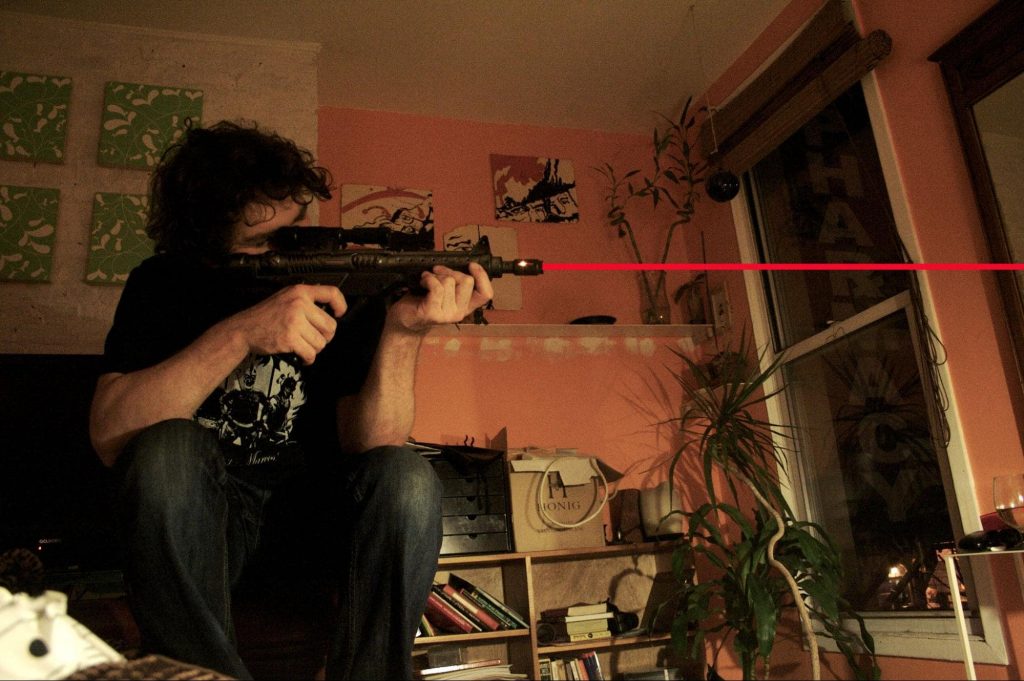 Man holding a gun with red laser